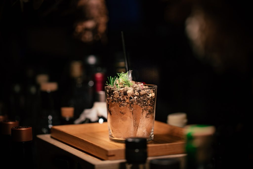 A drink served on a wooden tray with a straw.